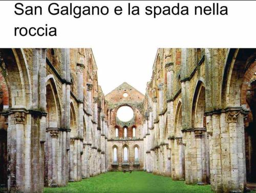 a view of an old cathedral with a green courtyard at Casa nella roccia in Roccastrada