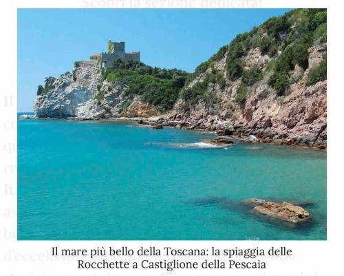 a view of a body of water with a castle on a hill at Casa nella roccia in Roccastrada