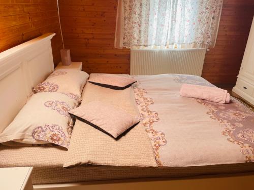 1 cama con 2 almohadas en una habitación en Pensiunea Alexolar en Mătişeşti