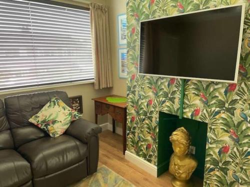 a living room with a couch and a flat screen tv at Bryn Castell, Conwy in Conwy