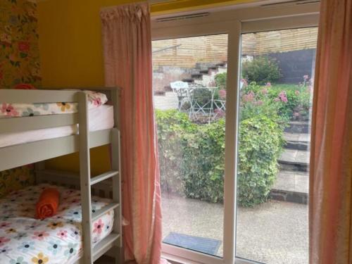a bedroom with a sliding glass door to a garden at Bryn Castell, Conwy in Conwy