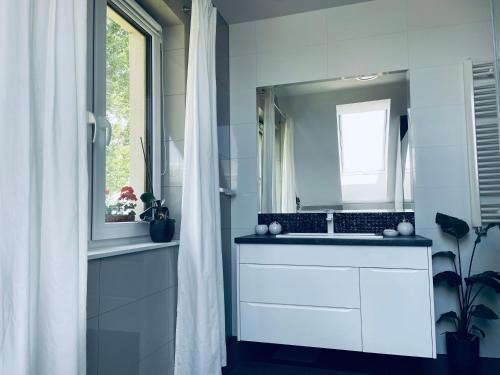 a white bathroom with a sink and a window at Żuławski Chillout in Stanisławowo