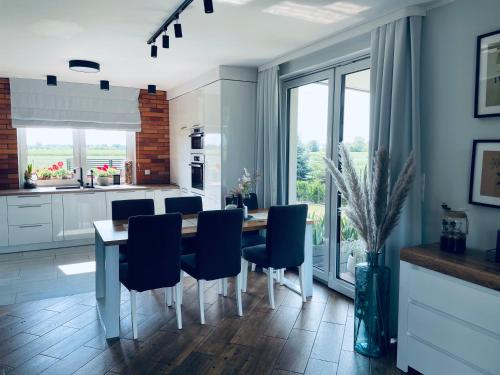 a kitchen with a dining table and blue chairs at Żuławski Chillout in Stanisławowo