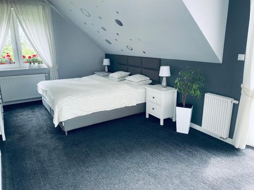 1 dormitorio con cama blanca y pared azul en Żuławski Chillout 