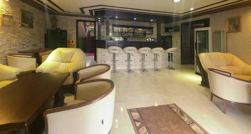 a restaurant with chairs and tables and a bar at Villa Florencia in Bardejov