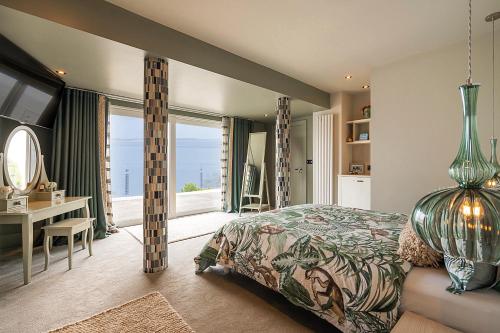 NEWCASTLE stunning sea views & forest backdrop في نيوكاسل: غرفة نوم بسرير ومكتب ونافذة
