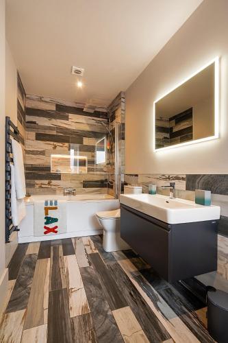 a bathroom with a sink and a tub and a toilet at Nest in Newcastle