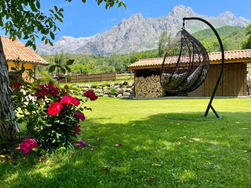 a swing in a yard with mountains in the background at Hotel Eigón in Posada de Valdeón