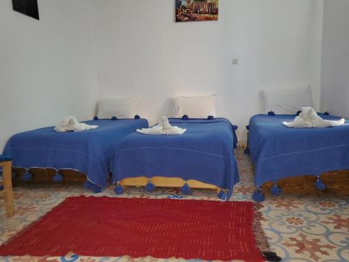 two beds with towels on them in a room at Riad AYLAL in Essaouira