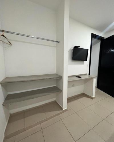 a white room with a tv and a shelf at Apartahotel y Hotel Sofichic Boutique in Barranquilla