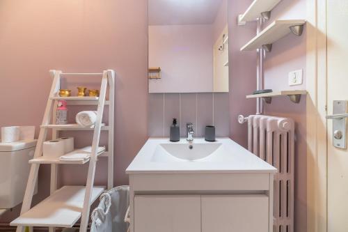 małą łazienkę z umywalką i półką w obiekcie Le Dejoux - Appartement avec terrasse en centre ville w mieście Vichy