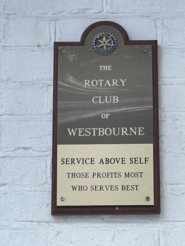 een bord op een witte bakstenen muur met een garantie club van Westbournefrinefrine bij THE LODGE BOURNEMOUTH in Bournemouth