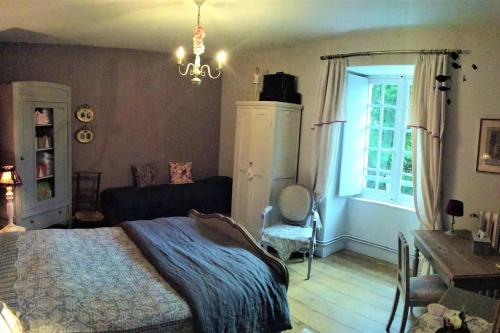 a bedroom with a bed and a chandelier at La grand' maison in Vorly