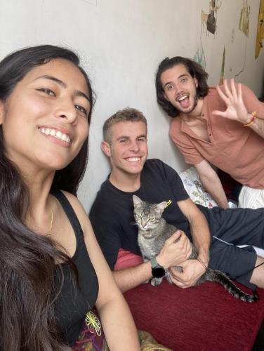 a group of people sitting on a bed with a cat at Nextdoor Patan in Pātan