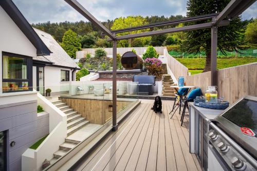 a deck with a view of a house at NEWCASTLE stunning sea views & forest backdrop in Newcastle