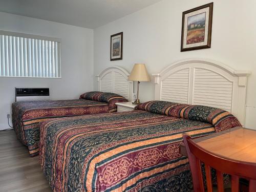 a hotel room with two beds and a table at Shell Motel Hollywood in Hollywood