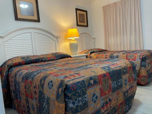 a hotel room with two beds and a lamp at Shell Motel Hollywood in Hollywood