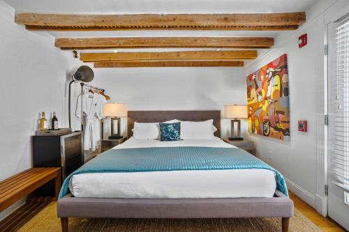 a bedroom with a large bed with a blue blanket at ZEY HOTEL in Greenport