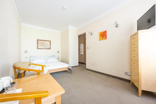 a room with a bed and a desk and a table at Willa Bór in Zakopane