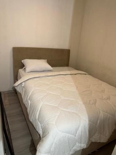 uma cama branca com uma almofada em cima em SİSLİ MERKEZ em Istambul