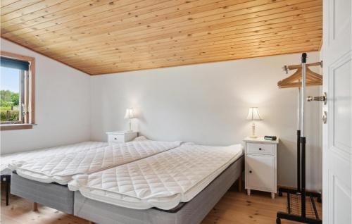 a bedroom with a bed and a wooden ceiling at Stunning Home In Jgerspris With Kitchen in Jægerspris