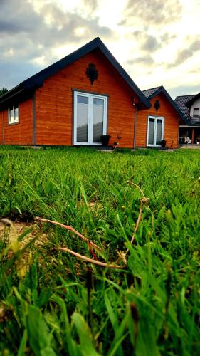 a house with a field of grass in front of it at Spiska Dolina in Łapsze Niżne