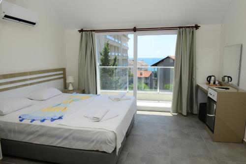a bedroom with a bed and a large window at Lofts Alanya Lina in Okurcalar