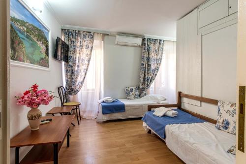 1 Schlafzimmer mit 2 Betten, einem Schreibtisch und einem Tisch in der Unterkunft old-historical corfu-town house in Korfu-Stadt