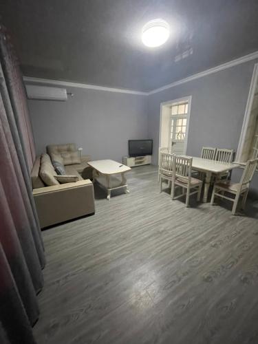 uma sala de estar com um sofá e uma mesa em Квартира дом в общем дворе em Samarkand