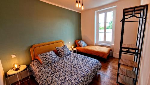 a bedroom with a bed and a chair and a window at La Villa 1848 in Épinac-les-Mines