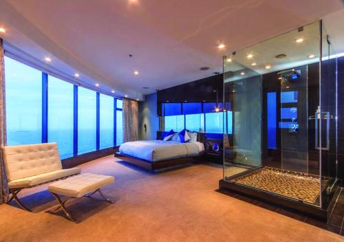 a bedroom with a bed and a glass shower at Pearls of Umhlanga Multi-Story Penthouse in Durban