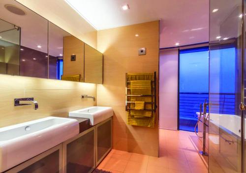 a bathroom with two sinks and a large mirror at Pearls of Umhlanga Multi-Story Penthouse in Durban