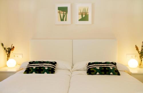 a bedroom with a white bed with two pillows at TALABERRI in Bermeo