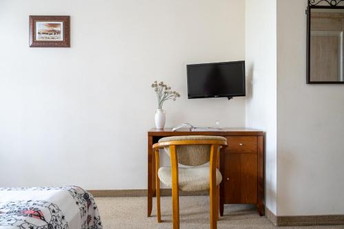 a room with a desk with a chair and a tv at Willa Bór in Zakopane