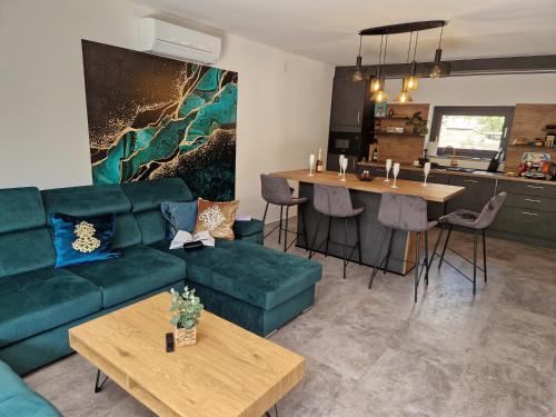 sala de estar con sofá verde y cocina en Villa Porta Krk en Krk