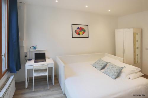 a bedroom with two beds and a desk with a laptop at AptCityStay in Apt