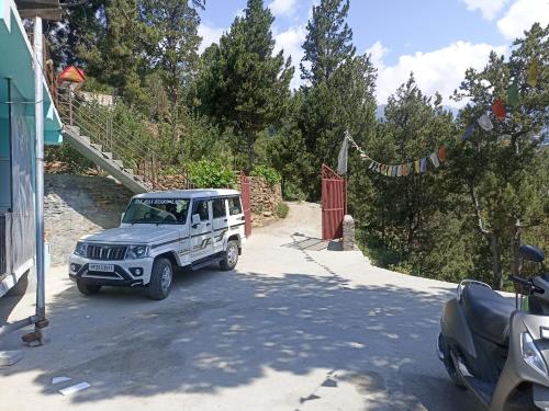 a white jeep parked on the side of a road at The Shudarang Inn in Kalpa