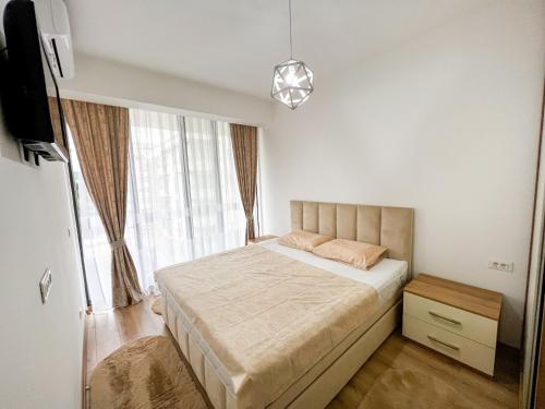 um quarto com uma cama e uma grande janela em Happy Home em Ulcinj