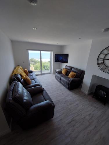 sala de estar con sofá de cuero y TV en Ocean View, en Newry