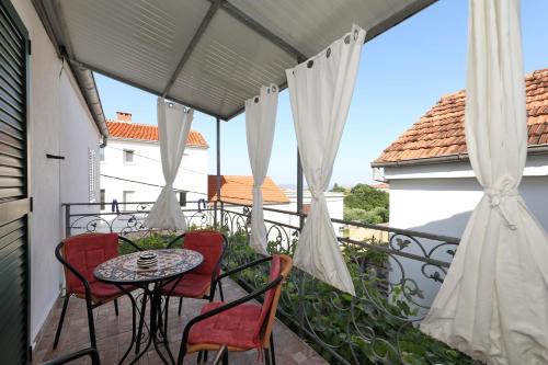 een patio met een tafel en stoelen op een balkon bij Apartment Rimanic in Zadar