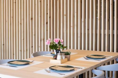 a wooden table with a vase of pink flowers on it at Das Hohenried in Freudenstadt