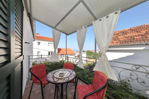 een patio met een tafel en stoelen op een balkon bij Apartment Rimanic in Zadar