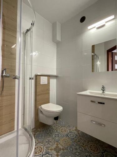 a bathroom with a toilet and a sink and a shower at Best in Karwia