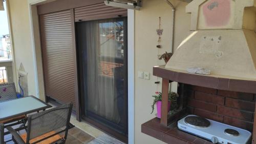 a living room with a brick fireplace next to a door at ANNASHOUSE in Nea Peramos