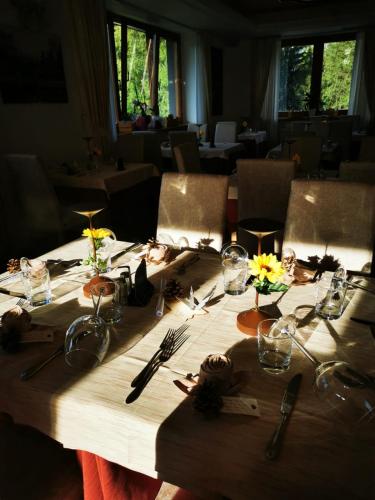 a wooden table with flowers and utensils on it at Hotel Fantelli in Folgarida