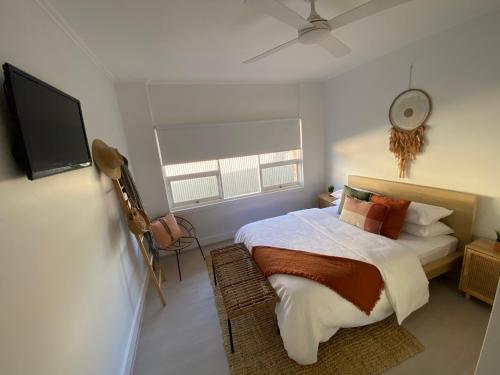 Un dormitorio con una cama y un televisor de pantalla plana. en The Sea Haven 200m to Henley Beach, en Henley Beach South