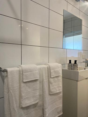 y baño con toallas blancas y lavamanos. en The Sea Haven 200m to Henley Beach, en Henley Beach South