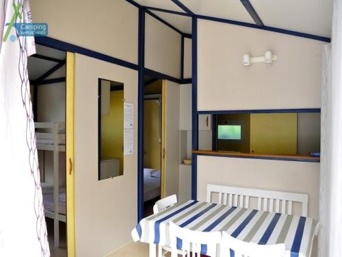 Habitación con cama de rayas azules y blancas en Camping Ampurdanes, en Roses