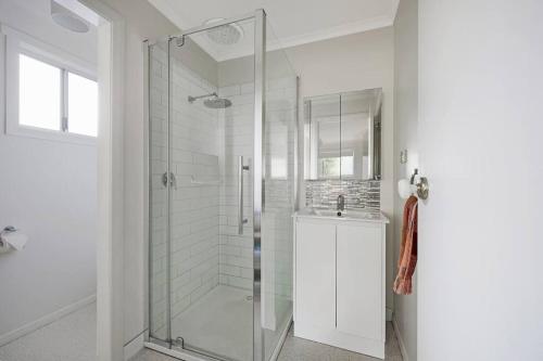 a white bathroom with a shower and a sink at Southern Ocean Retreat in Warrnambool