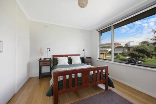 a bedroom with a bed and a large window at Southern Ocean Retreat in Warrnambool